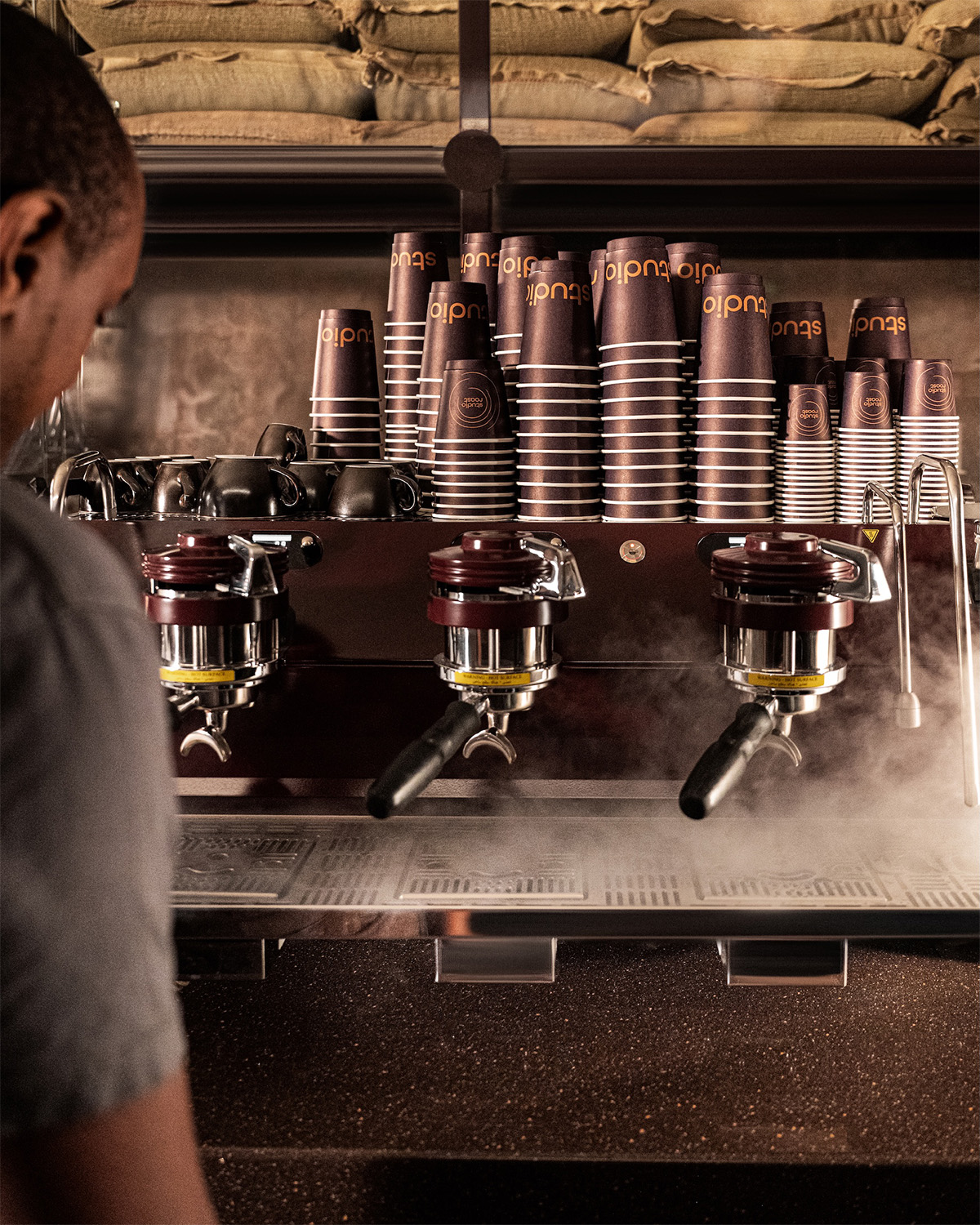 Studio Roast Barista Working with Cups Displayed on Espresso Machine